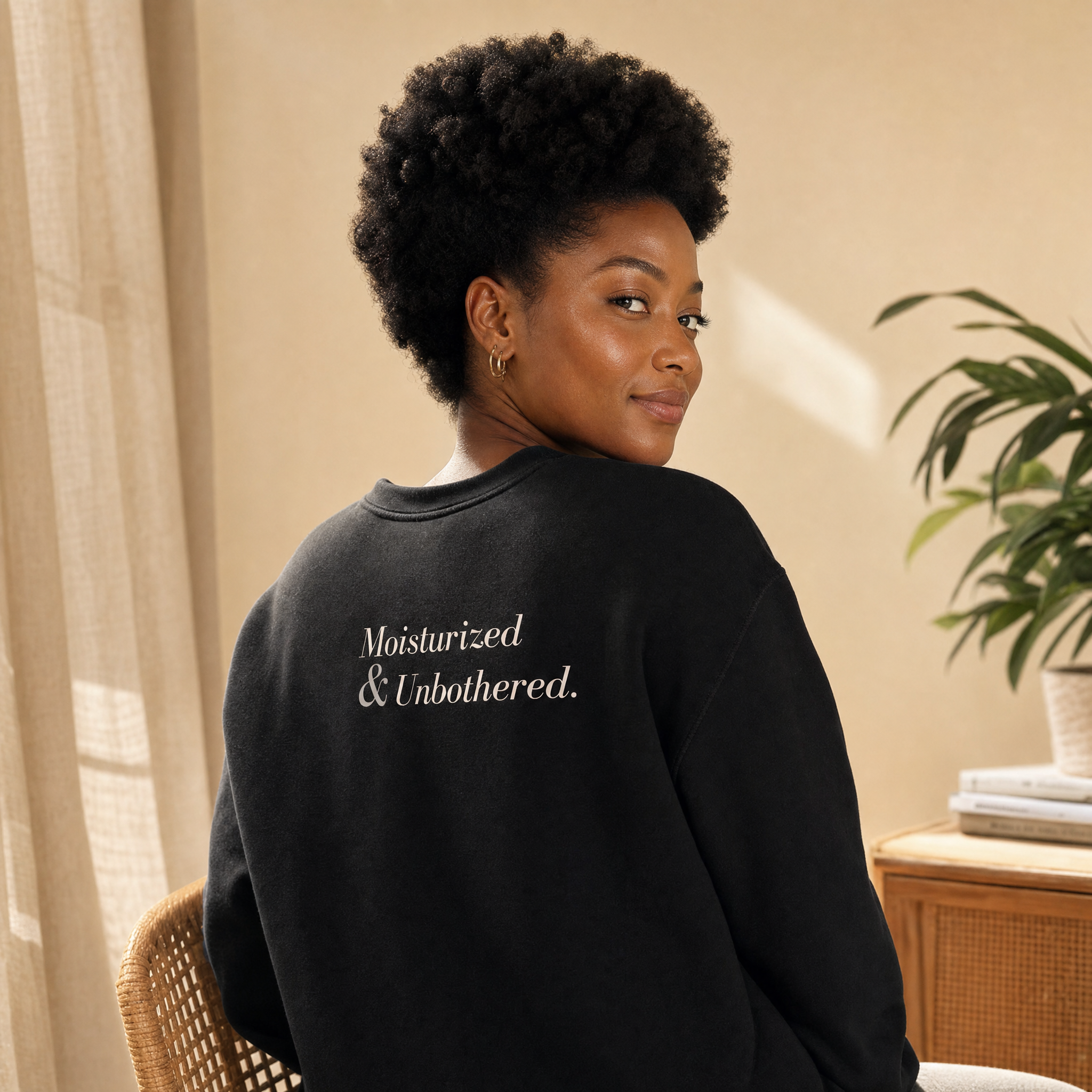 Black model in the Blackety Black Moisturized and Unbothered crewneck — Emotionally Black left chest in cream ink