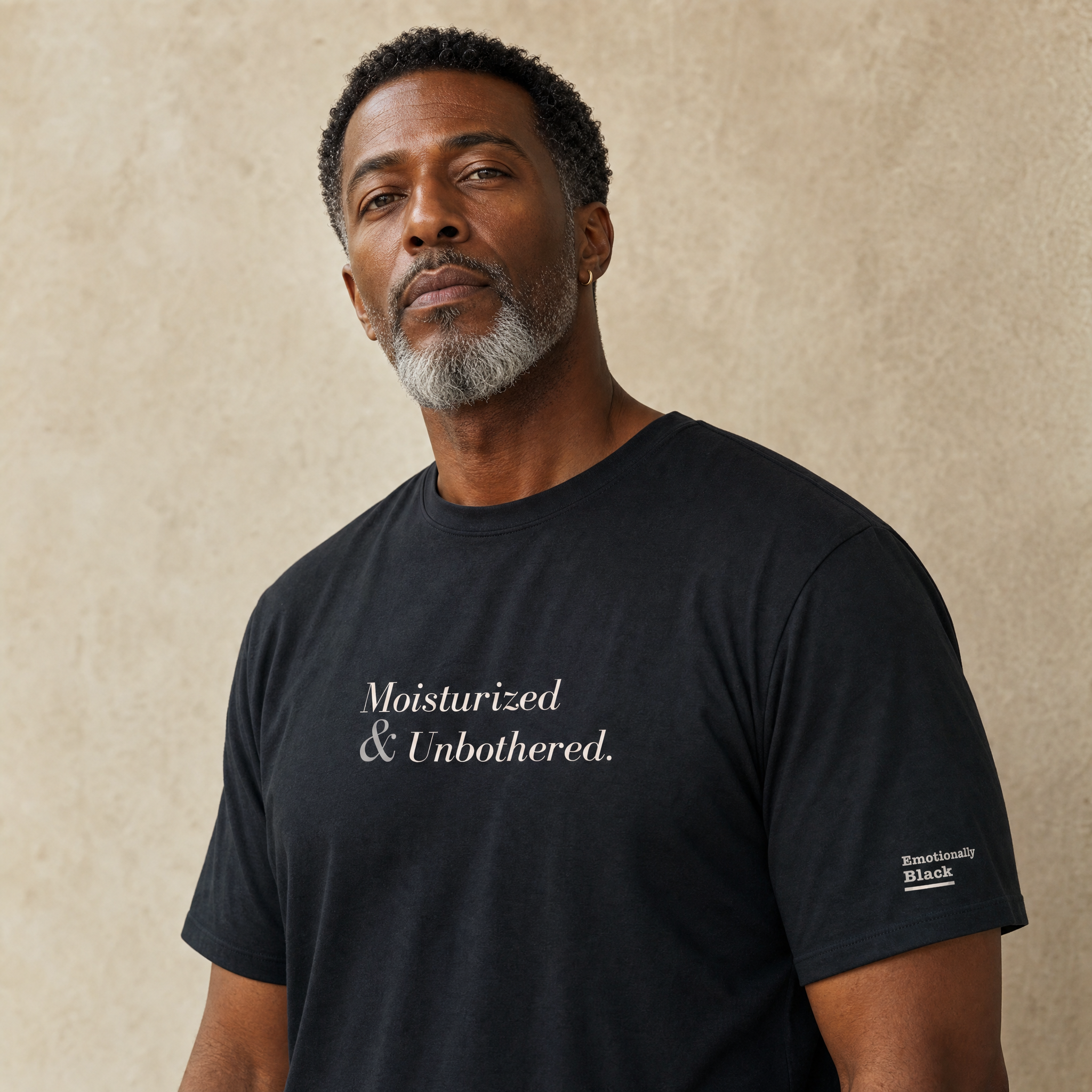 Black model in the Blackety Black Moisturized and Unbothered tee — cream-ink statement print on heavyweight black cotton